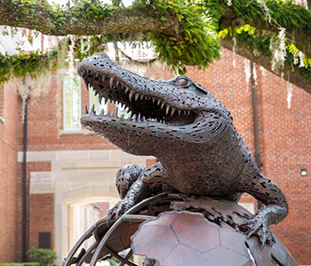 Statue of a gator on a globe